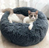Luxury round plush donut pet bed in gray with small cat resting comfortably inside
