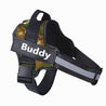Reflective adjustable no-pull dog harness in camouflage pattern with personalized name patch and sturdy handle for control and comfort.