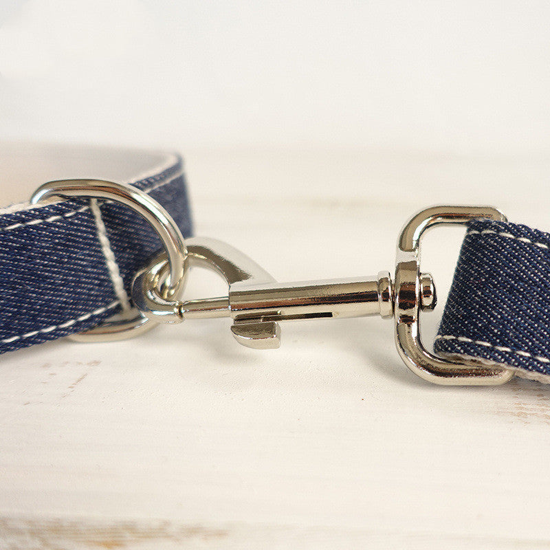 Close-up of MUTTCO Cowboy Dog Collar metal clasp and blue adjustable leather strap with white stitching