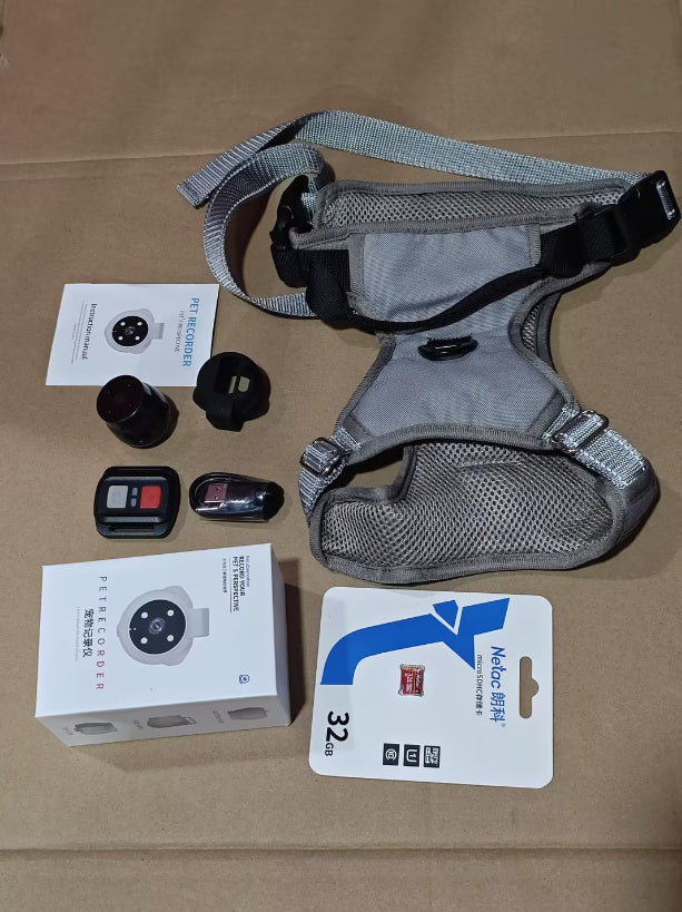 Pet Tracker Collar Camera set with gray adjustable strap harness, remote control, camera lens, protective shell, charging cable, 32GB memory card, and user manual on brown background